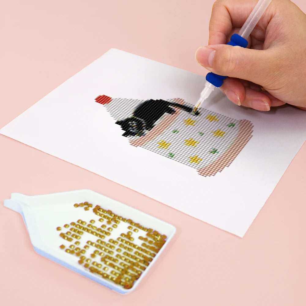 Close-up of drills being placed on a Christmas Black Cats mini diamond painting design