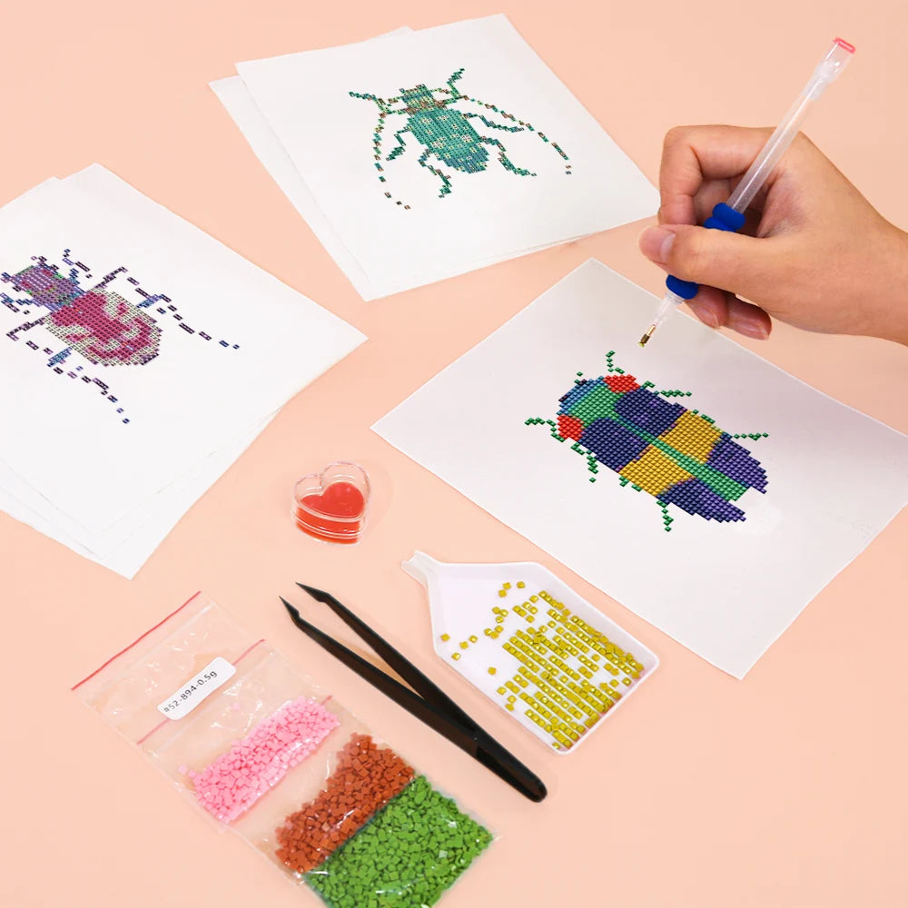 Working on several Colourful Beetles mini diamond painting designs with drills and applicator
